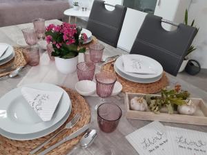 a table with white plates and bowls and flowers at Haus Mühlenbach in Mechernich