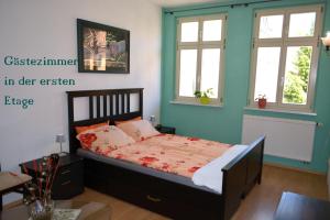 une chambre avec un lit avec des murs et des fenêtres bleus dans l'établissement Im Herzen der Altstadt von Naumburg-Saale, à Naumbourg