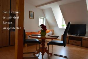 un salon avec une table et deux chaises ainsi qu'une télévision dans l'établissement Im Herzen der Altstadt von Naumburg-Saale, à Naumbourg