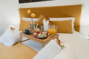 a tray of fruit and juice on a bed at Douro Garden & Rooftop Home in Vila Nova de Gaia