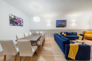 a living room with a blue couch and a table at Douro Garden & Rooftop Home in Vila Nova de Gaia