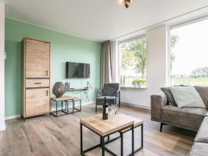 a living room with a couch and a table at Bij de Buren in Oploo