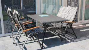 une table et des chaises assises sur une terrasse dans l'établissement Nettes Ferienhaus in Stavenisse mit Terrasse und Grill, à Stavenisse