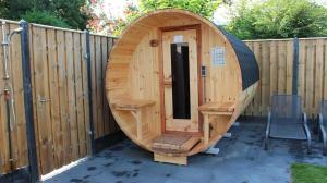 un sauna en bois avec une porte en bois dans une clôture dans l'établissement Nettes Ferienhaus in Stavenisse mit Terrasse und Grill, à Stavenisse