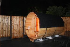 un sauna en bois avec une table devant une clôture dans l'établissement Nettes Ferienhaus in Stavenisse mit Terrasse und Grill, à Stavenisse 14 autres photos