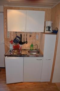a kitchen with white cabinets and a sink at Ferienwohnung Krummhörn Upleward in Krummhörn