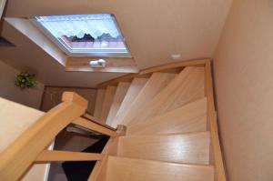 a spiral staircase in a room with a skylight at Ferienwohnung Krummhörn Upleward in Krummhörn