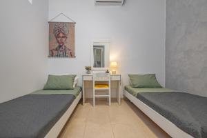 a room with two beds and a desk in it at Rania's House Faliraki in Faliraki