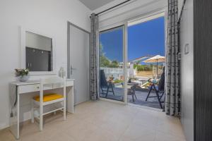 a room with a desk and a view of a patio at Rania's House Faliraki in Faliraki
