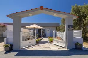 an arch with an umbrella and a patio at Rania's House Faliraki in Faliraki