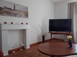 a living room with a tv and a coffee table at Ferienwohnung in Stoltebüll mit Kleiner Terrasse in Stoltebüll