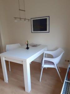 a white table and a chair in a room at Ferienwohnung in Stoltebüll mit Kleiner Terrasse in Stoltebüll