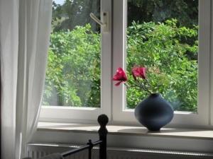 a vase sitting on a window sill with a flower in it at Ferienwohnung in Stoltebüll mit Kleiner Terrasse in Stoltebüll +14 photos