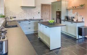 a large kitchen with white cabinets and a counter at Looshof in Helchteren