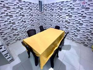 a yellow table and chairs in a room with a brick wall at Hotel Rancho Grande in Barranquilla