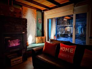 un salon avec un canapé et une cheminée dans l'établissement Host Patagonia, à Plaza Huincul