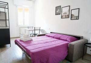 Una gran cama morada en una habitación con una mesa. en Molinari House Modena Smeraldino, en Módena