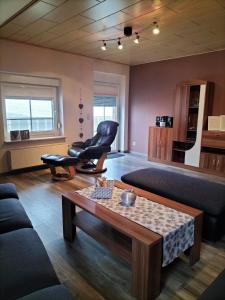 a living room with a chair and a table at Ferienwohnung Naturblick in Uslar