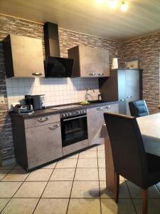 a kitchen with stainless steel appliances and a table at Ferienwohnung Naturblick in Uslar +10 photos