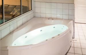 a white bath tub in a bathroom with a window at Bjørnehiet - Hytte 6 in Øvre Ramse