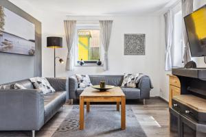 a living room with a couch and a table at Komplett umzäuntes Ferienhaus Plauer See mit Hund in Zislow