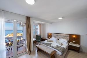 a bedroom with a bed and a view of the ocean at Hotel Adrović in Sveti Stefan