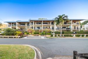 an empty street in front of a large apartment building at Whitsunday Beachfront Apartment on Coral Esplanade in Cannonvale