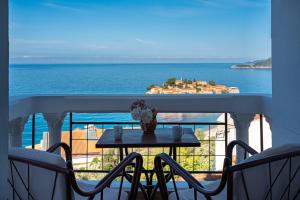 a table on a balcony with a view of the ocean at Hotel Adrović in Sveti Stefan