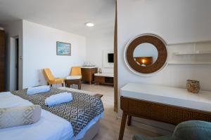 a bedroom with two beds and a mirror at Hotel Adrović in Sveti Stefan