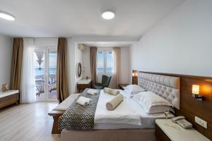 a hotel room with a large bed and a phone at Hotel Adrović in Sveti Stefan