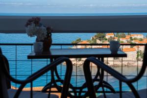 a table and chairs with a view of the water at Hotel Adrović in Sveti Stefan
