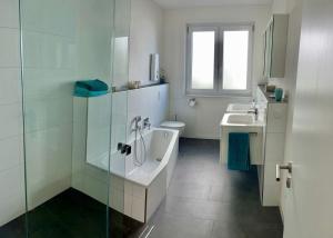 a bathroom with a tub and a sink and a shower at Moderne Wohnung mit Parkplatz und Rheinblick in Boppard