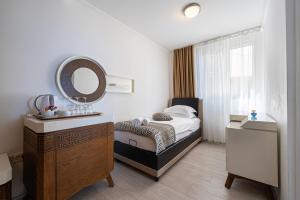 a bedroom with a bed and a mirror and a sink at Hotel Adrović in Sveti Stefan