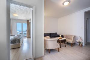 a bedroom and a living room with a bed and a table at Hotel Adrović in Sveti Stefan