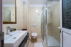 a bathroom with a sink and a toilet and a shower at Hotel Adrović in Sveti Stefan