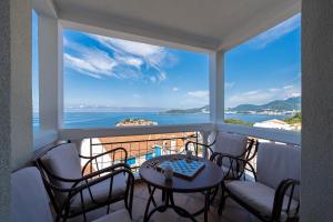 a balcony with a table and chairs and a view of the ocean at Hotel Adrović in Sveti Stefan