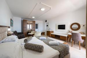 a bedroom with two beds and a living room at Hotel Adrović in Sveti Stefan