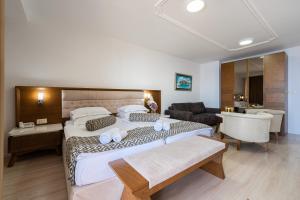 a bedroom with two beds and a living room at Hotel Adrović in Sveti Stefan