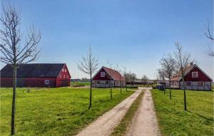 a dirt road in a field with two red barns at 3 Bedroom Awesome Home In Viken in Viken