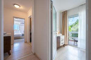 a bathroom with a large window and a bedroom at Hotel Adrović in Sveti Stefan