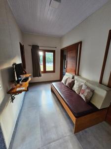 a living room with a couch and a desk at Pousada Aracê in Pedra Azul