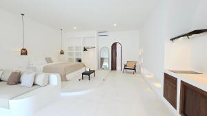 Un dormitorio blanco con una cama y un sofá. en La Bianca Studio Apartment, en Dalung
