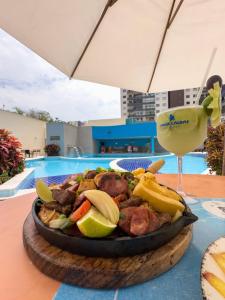 un plato de comida en una mesa con una bebida en ATRIUM THERMAS Residence Service, en Caldas Novas