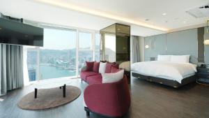 a hotel room with a bed and a couch at Lavalse Hotel in Busan