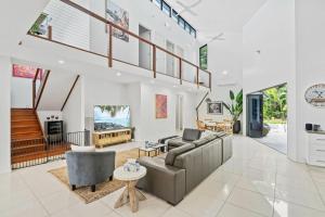 a living room with a couch and a table at Belle Escapes Villa Aurelia in Palm Cove