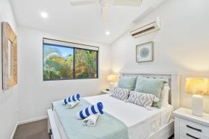 a bedroom with a bed and a window at Belle Escapes Villa Aurelia in Palm Cove +30 photos