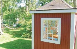 a red shed with a window in a yard at Lindersgården in Staffanstorp