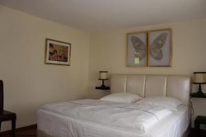 a white bed in a bedroom with two pictures on the wall at Ferienhaus für 6 Personen ca 126 m in Alsbach, Rhein Mittelrheintal in Alsbach
