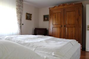 a bedroom with a white bed and a wooden door at Ferienhaus für 6 Personen ca 126 m in Alsbach, Rhein Mittelrheintal in Alsbach
