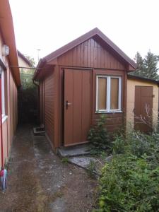a small building with a door and a window at Ferienhaus in Oranienburg mit Terrasse, Grill und Garten in Oranienburg +14 photos